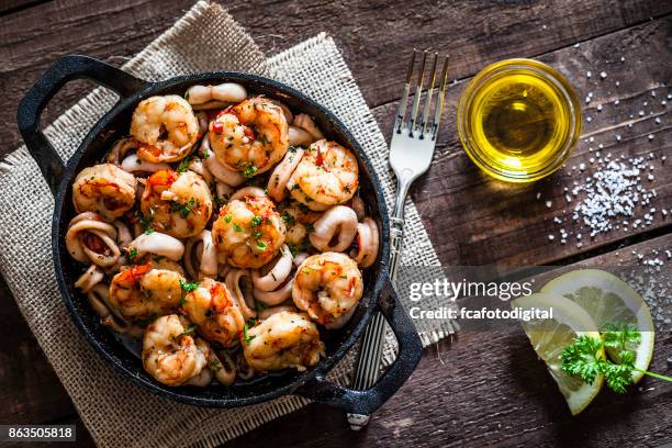 garnalen en inktvis ringen gekookt op ijzer gegoten pan - shrimp seafood stockfoto's en -beelden