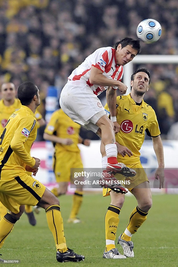 Olympiakos' Luciano Galletti (R) fights