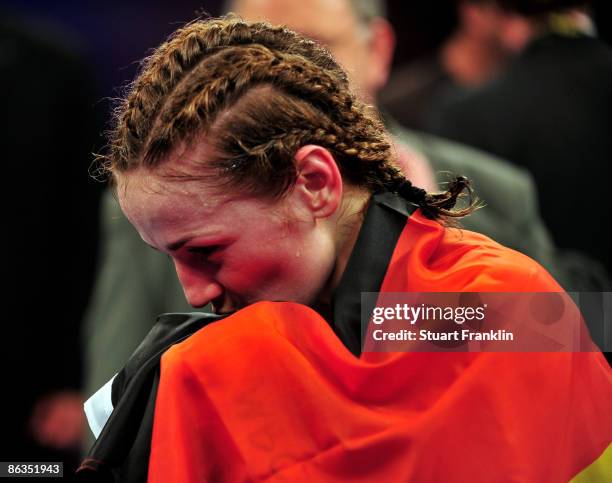 Ina Menzer of Germany kisses the German flag as she celebrates after winning her fight against Franchesca Alcanter of USA during the WIBF and WBC...