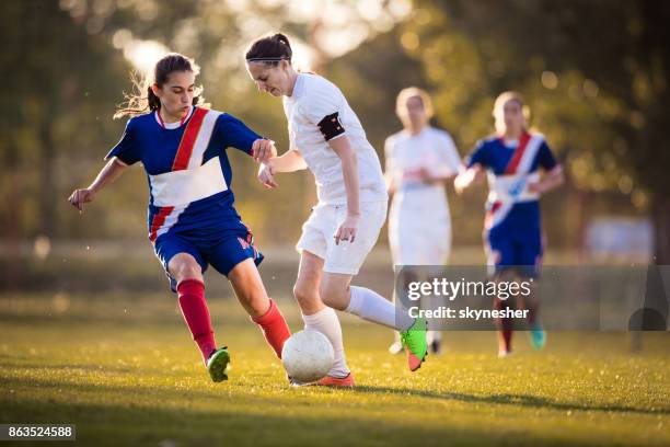 weibliche fußball-spieler in aktion auf einem spielfeld bestimmt. - frauenfußball stock-fotos und bilder