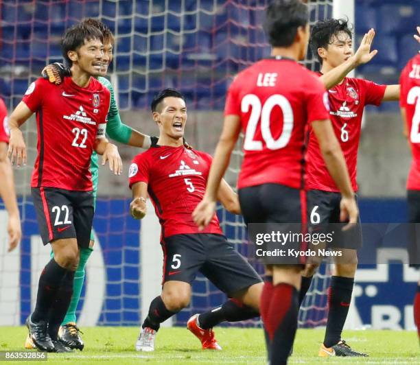 Urawa Reds players celebrate after defeating Shanghai SIPG 1-0 in the second leg of their Asian Champions League semifinal in Saitama, Japan, on Oct....