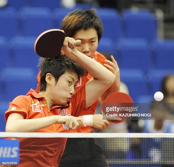 China's Guo Yue returns the ball as her partner Li Xiaoxia looks on during their women's doubles quarter finals against Japan's Ai Fukuhara and...
