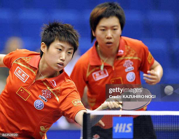 China's Guo Yue returns the ball as her partner Li Xiaoxia looks on during their women's doubles quarter finals against Japan's Ai Fukuhara and...