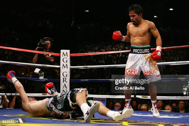 Manny Pacquiao of the Philippines stands over Ricky Hatton of England after Pacquiao knocked him out in the second round during their junior...