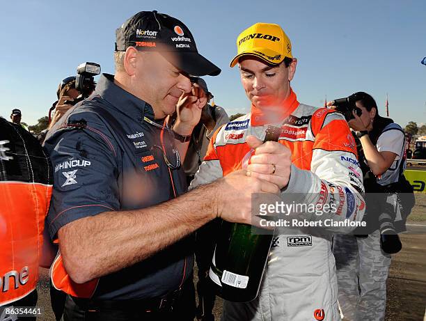 Triple Eight team owner Roland Dane congratulates Craig Lowndes driver of the Team Vodafone Ford after winning race two of round three of the V8...