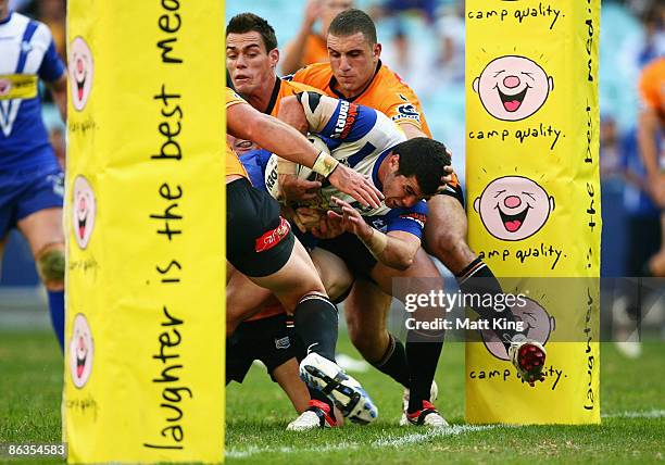 Michael Ennis of the Bulldogs tries to get over the line during the round eight NRL match between the Bulldogs and the Wests Tigers at ANZ Stadium on...