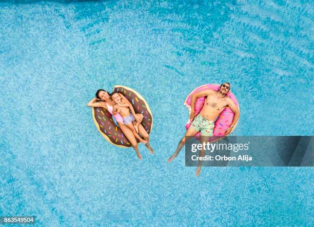 family relaxing at swimming pool - pool raft imagens e fotografias de stock