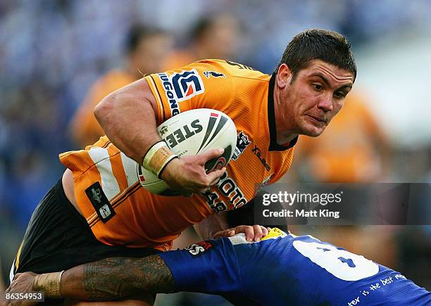 Chris Heighington of the Tigers takes on the defence during the round eight NRL match between the Bulldogs and the Wests Tigers at ANZ Stadium on May...