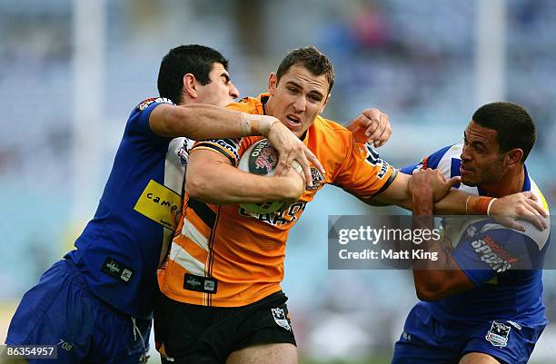 Dean Collis of the Tigers takes on the defence during the round eight NRL match between the Bulldogs and the Wests Tigers at ANZ Stadium on May 3,...