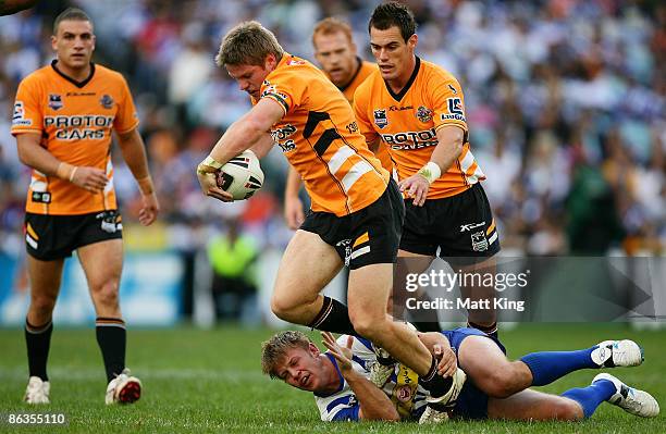 Chris Lawrence of the Tigers breaks from the tackle of David Stagg of the Bulldogs during the round eight NRL match between the Bulldogs and the...