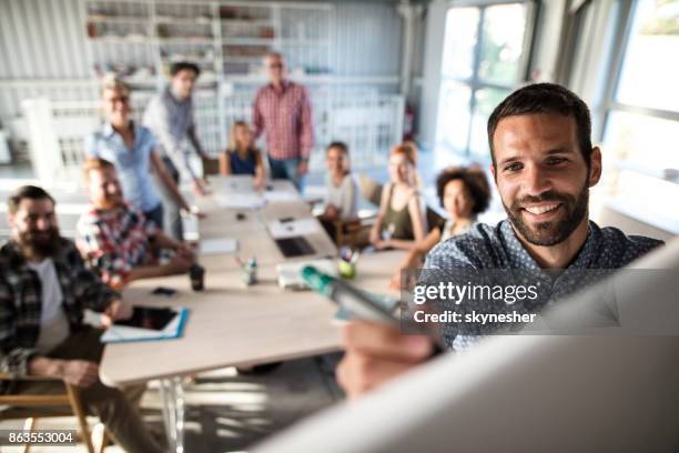 empresário de feliz escrevendo no quadro durante a apresentação do negócio no escritório. - quadro branco - fotografias e filmes do acervo