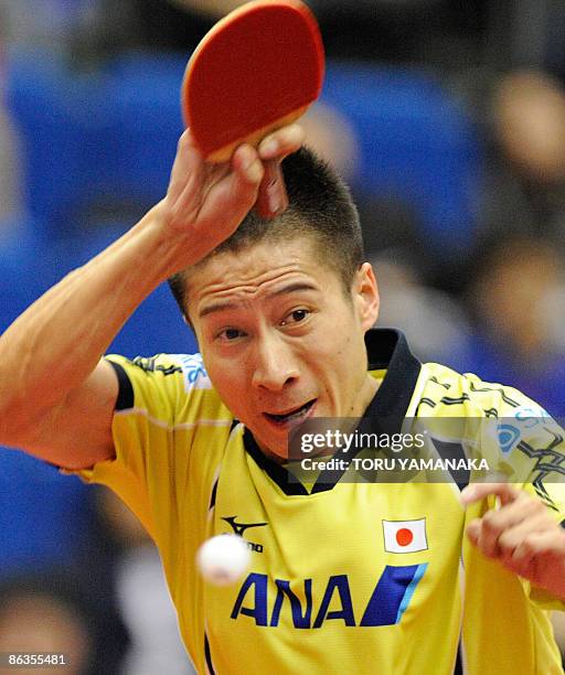 Japanese Kaii Yoshida smashes the ball against Wang Hao of China during their men's singles quarter-final match in the World Table Tennis...