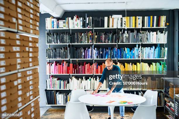 man working in creative studio - bookshelf stock pictures, royalty-free photos & images