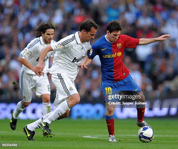 Lionel Messi of Barcelona duels for the ball with Christoph Metzelder of Real Madrid during the La Liga match between Real Madrid and Barcelona at...