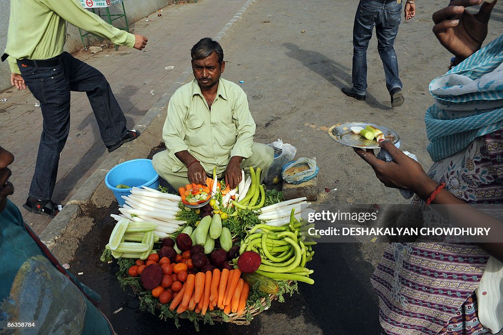 Indian passersby take fruits and vegetab