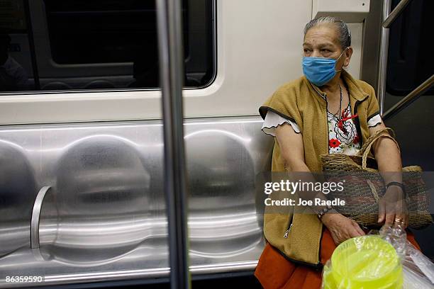 Women rides the subway as she wears a surgical masks, to help prevent being infected with the swine flu on May 3, 2009 in Mexico City, Mexico. The...