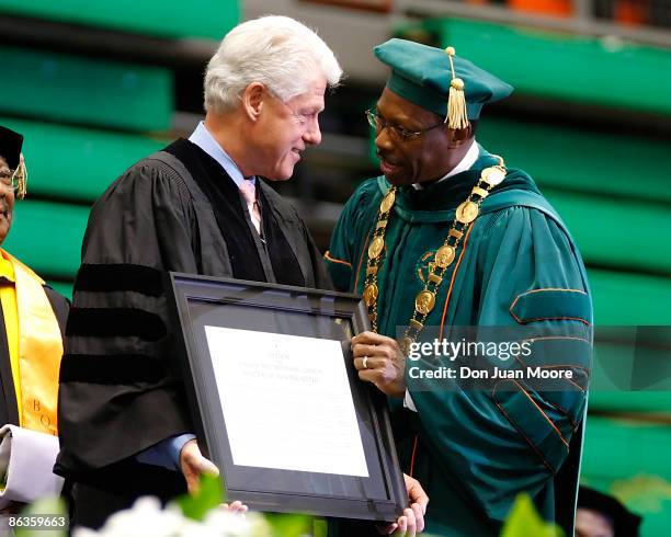 Former President Bill Clinton receives an honarary degree from Florida A&M University's President James H. Ammons during the '09 graduation at...