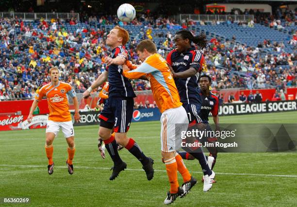 Bobby Boswell of the Houston Dynamo shoots against the defense of Jeff Larentowicz and Shalrie Joseph of the New England Revolution at Gillette...