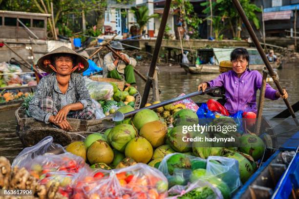 vietnamese woman selling coconuts on floating market, mekong river delta, vietnam - can tho province stock pictures, royalty-free photos & images