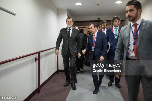 Mariano Rajoy, Spain's prime minister, left, heads to a news conference at a European Union leaders summit in Brussels, Belgium, on Friday, Oct. 20,...