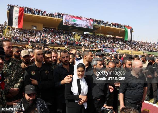 Relatives Brigadier General Issam Zahreddine are escorted through a stadium as Syrians gather to attend his funeral in the southern city of Suwaida...