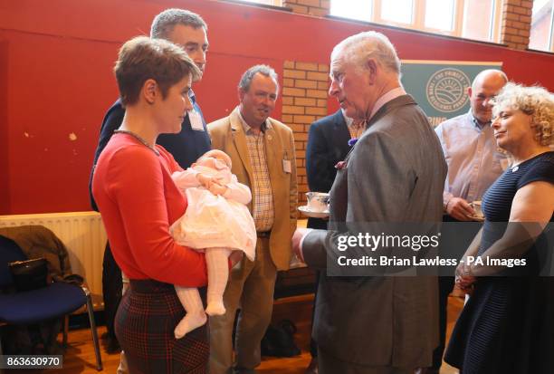 The Prince of Wales speaks to poultry farmers Nicola Hempton, her husband Thomas and their daughter 11-week-old Lyla, during a visit to the YMCA...