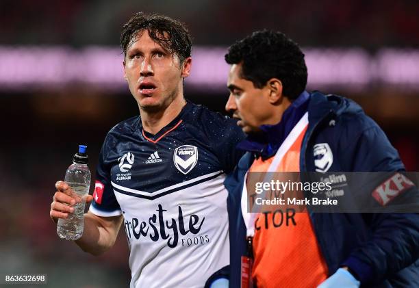 Melbourne's Mark Milligan goes off after being sandwiched between Adelaides Vince Lia and Melbourne's Leigh Broxham defending a goal during the round...