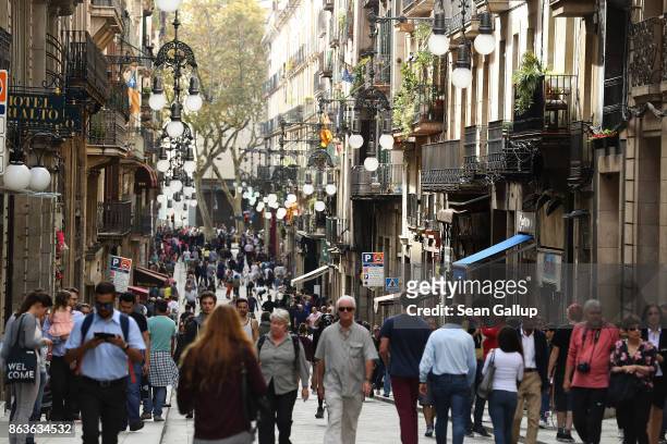 Visitors walk along Carrer de Ferran street in the Gothic quarter on October 20, 2017 in Barcelona, Spain. As the Catalan independence crisis deepens...