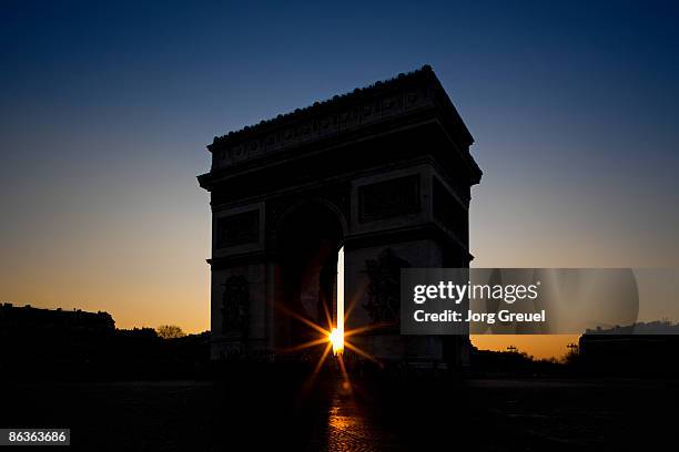 arc de triomphe at sunset - arc de triomphe paris stock pictures, royalty-free photos & images