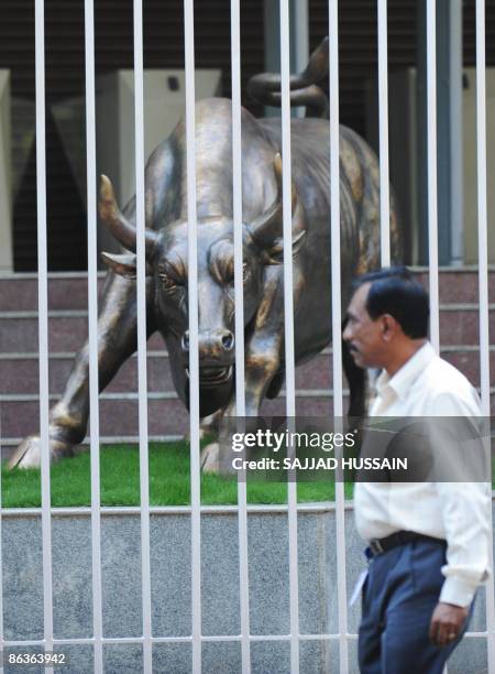 An Indian man walks past the bronze bull statue outside the Bombay Stock Exchange in Mumbai on May 4, 2009. Indian shares climbed more than 5.5...