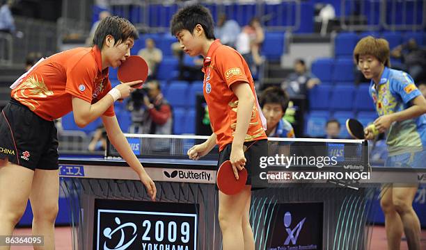 Chinese pair Li Xiaoxia and Guo Yue discuss their move during a match against compatriot Ding Ning and Guo Yan in the women's final match at the...