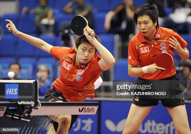 China's Guo Yue returns the ball as her partner Li Xiaoxia looks on during the women's final match against their compatriot Ding Ning and Guo Yan at...