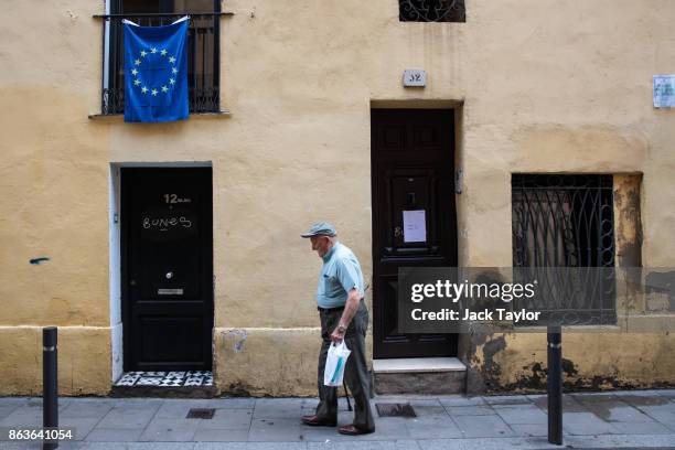 Man walks past a building with a European flag hanging from a balcony on October 20, 2017 in Barcelona, Spain. The Spanish government is to take...