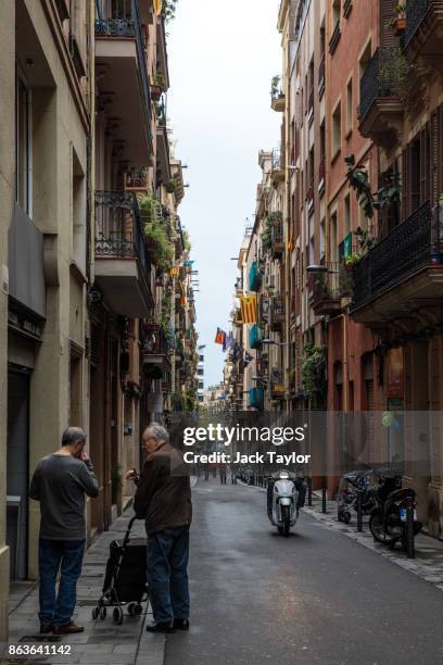 Man rides a scooter down a street where Catalan independence flags hang from buildings on October 20, 2017 in Barcelona, Spain. The Spanish...