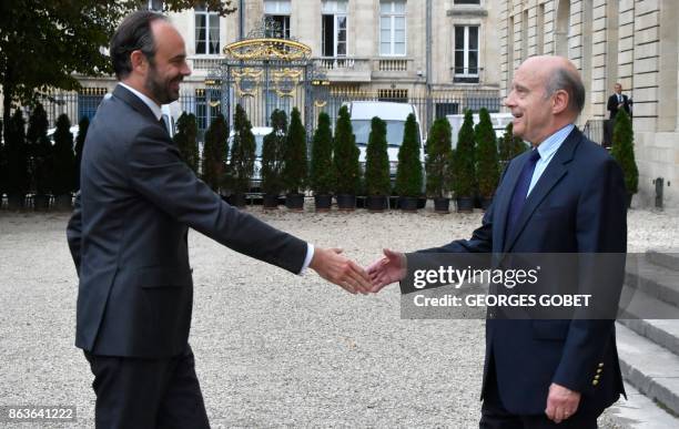 French Prime Minister Edouard Philippe shakes hands with former Prime Minister and current Mayor of Bordeaux Alain Juppe as he arrives at The Town...