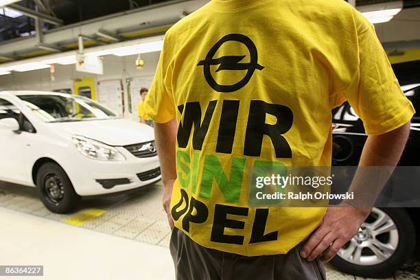 An employee of German carmaker Adam Opel GmbH stands next to an Opel Corsa at a plant on May 4, 2009 in Eisenach, Germany. Representatives of the...