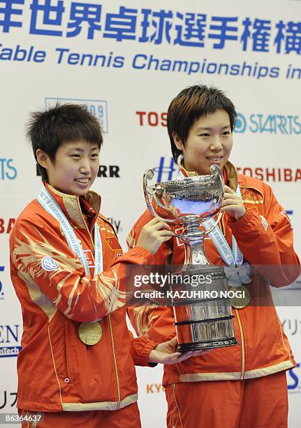 Chinese pair Guo Yue and Li Xiaoxia hold the trophy during an awarding ceremony for the women's doubles final in the World Table Tennis Championships...