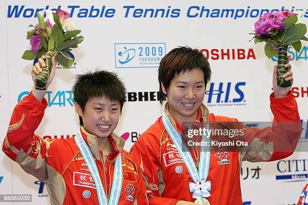 Guo Yue and Li Xiaoxia of China celebrate on the podium with their winners medals during the award ceremony for the Women's Doubles final match of...