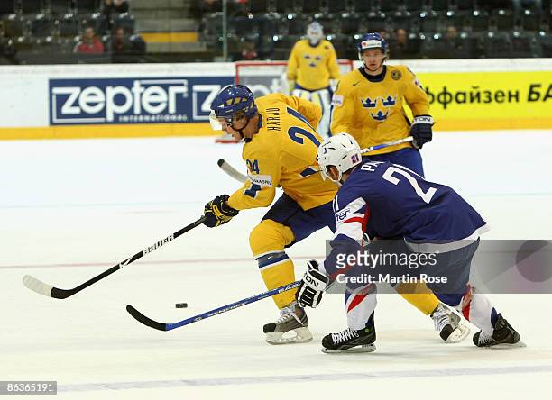 Johan Harju of Sweden fights for the puck with Cyril Papa of France during the IIHF World Ice Hockey Championship qualification round match between...