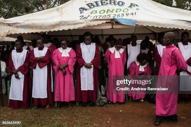 Church choir prays at a funeral service for three men killed by the police in an opposition protest the week prior, on October 20, 2017 in Bondo,...