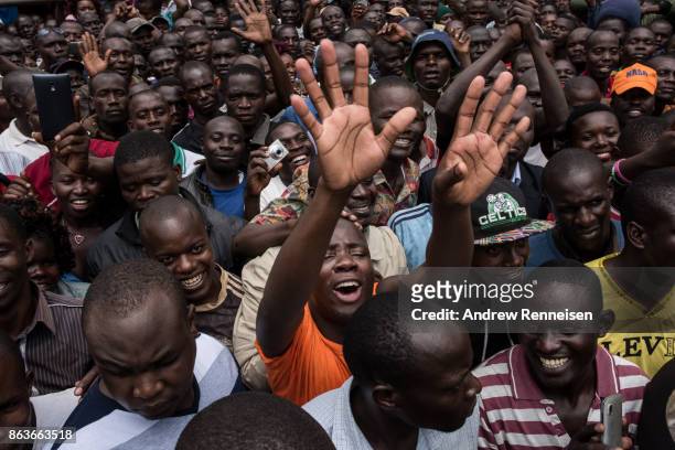 Supporters react to a speech by opposition candidate Raila Odinga at a funeral service for three men killed by the police in a protest the week...