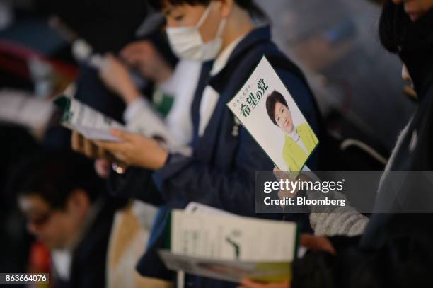 Attendees hold campaign pamphlets featuring an image of Yuriko Koike, governor of Tokyo and leader of the Party of Hope, during an election campaign...