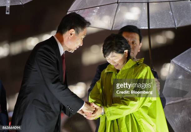 Seiji Maehara, leader of the Democratic Party, left, shakes hands with Yuriko Koike, governor of Tokyo and leader of the Party of Hope, during an...