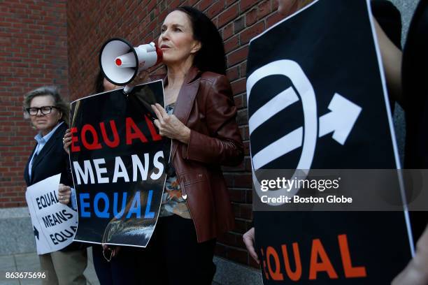 Attorney Wendy Murphy, center, speaks through a bullhorn as she and a small group of other women protest the Trump administration's rollback of...