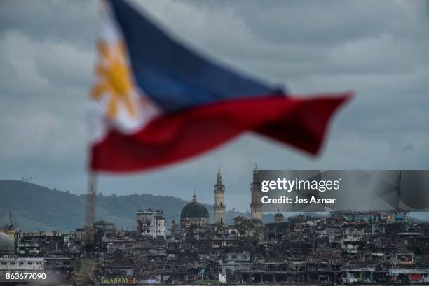 The Philippine flag is seen waving over the besieged city of Marawi on October 20, 2017 in Marawi, southern Philippines. President Rodrigo Duterte...