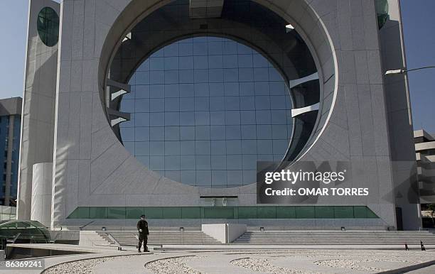 Soldier wearing a face mask guards one of the modern architecture builidings in Santa Fe, an exclusive business area of Mexico city on May 04, 2009....