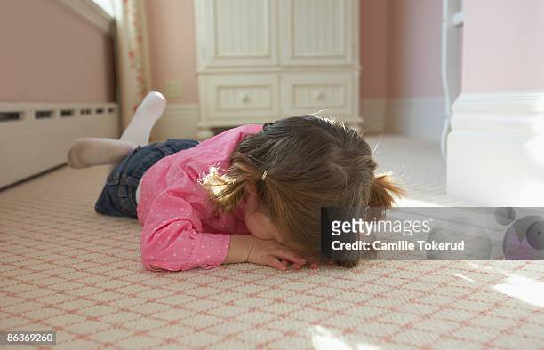 young girl laying on bedroom carpet covering face - tantrum stock pictures, royalty-free photos & images