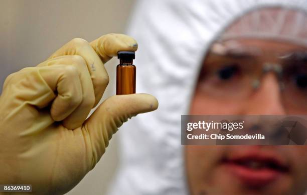 Manufacturing Engineer Nate Forrest holds a small glass vial like those that will hold tuberculosis vaccines during a tour of the Aeras Global TB...