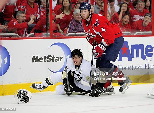 John Erskine of the Washington Capitals drops Sidney Crosby of the Pittsburgh Penguins to the ice as his helmet falls off during Game One of the...