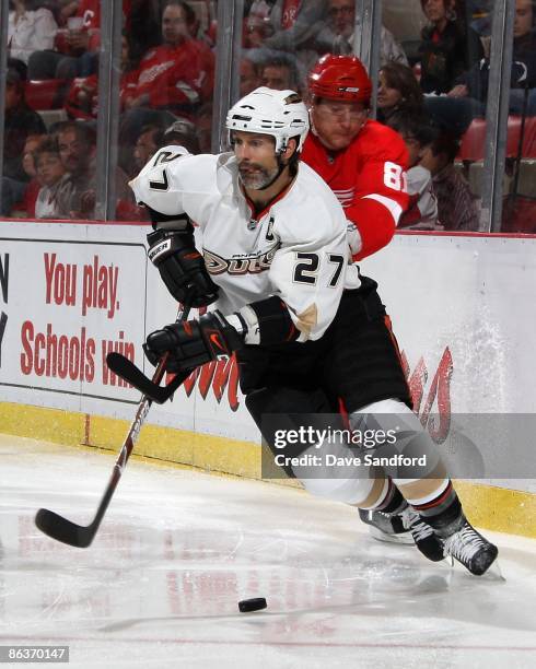 Scott Niedermayer of the Anaheim Ducks skates with the puck as Marian HOssa of the Detroit Red Wings gives chase during Game One of the Western...